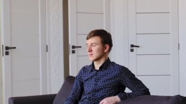 Yakışıklı genç adamın kapalı alanda çekilmiş yakın çekim görüntüleri.