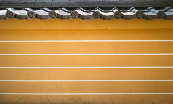 Uma parede de tijolo amarelo-marrom de um palácio histórico asiático Fotografia De Stock