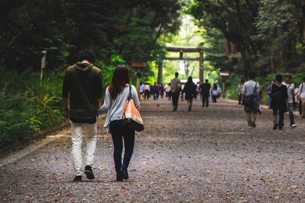 Um casal de mãos dadas andando juntos em um parque Imagem De Stock