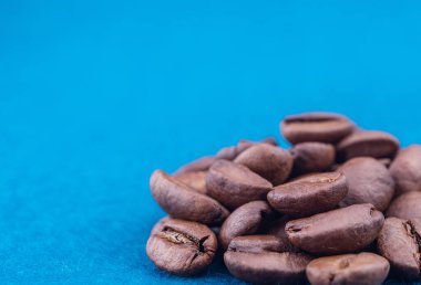 Sağ alt köşedeki mavi halıda kavrulmuş kahve çekirdekleri.