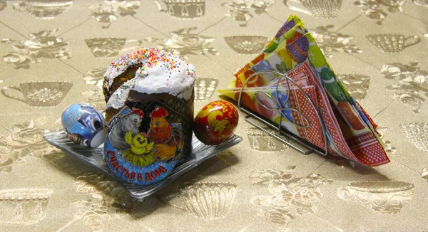 Paskalya tatili. Tabakta paskalya pastası. Tatil etiketli yumurtaların yanında renkli yumurta resmi olan altlıklar. Evdeki mutluluk yazıtları..