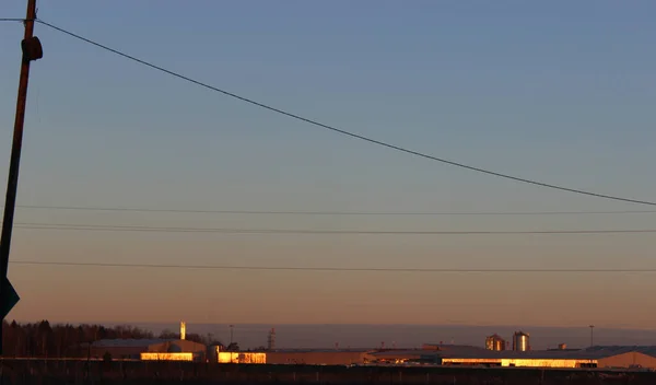 Endüstriyel binalar sabah güneşinin ışınlarını yansıtır. Gökyüzüne karşı binalar.