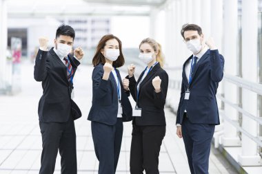 Enfeksiyonu önlemek için maske takan çok uluslu iş adamlarından oluşan bir ekip