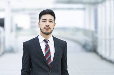 20 'li yaşlarda, siyah takım elbiseli bir iş adamının açık hava portresi.
