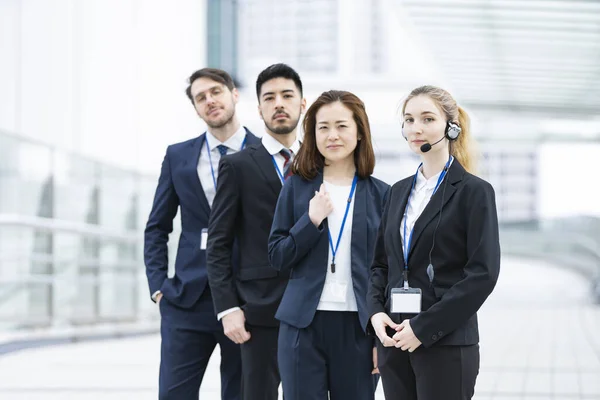 Jovem Operadora Usando Fone Ouvido Sua Equipe Negócios — Fotografia de Stock