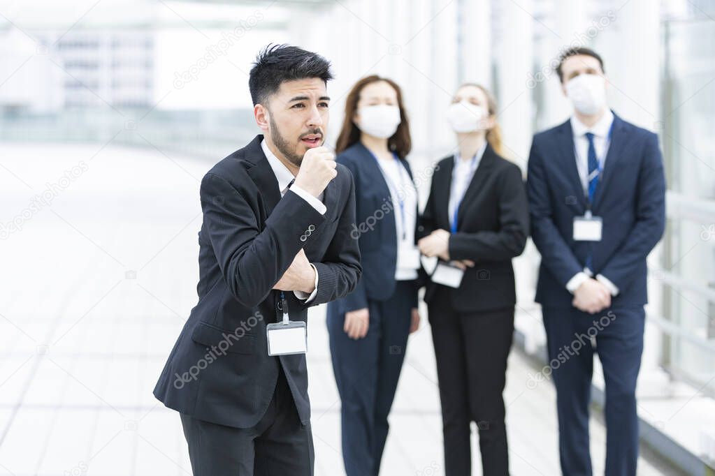 Businessman holding his mouth with his hand coughing without wearing a mask
