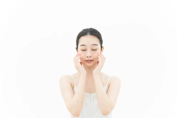 肌に触れ 肌の状態を確認するアジア系の若い女性 — ストック写真