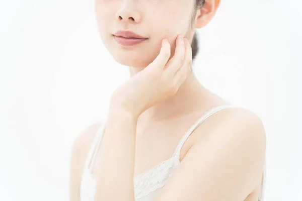 肌に触れ 肌の状態を確認するアジア系の若い女性 — ストック写真