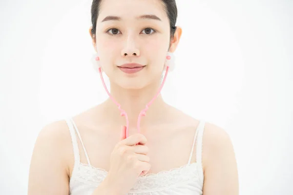 Μια Νεαρή Ασιάτισσα Γιαπωνέζα Που Χρησιμοποιεί Μια Μικρή Συσκευή Μασάζ — Φωτογραφία Αρχείου