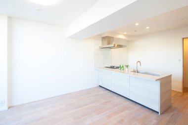 Beyaz tonlu bir dairede parlak ve temiz bir mutfak.