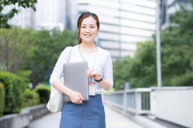 Asyalı (Japonca) kadın ofis çalışanı dışarıda dizüstü bilgisayarla çalışıyor