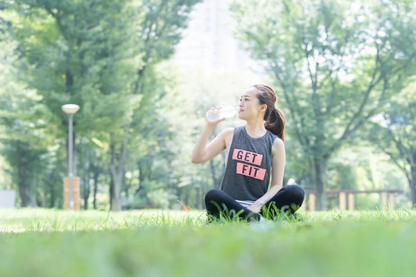 Asiatique Jeune Femme Hydratant Tout Faisant Yoga Dans Parc — Photo