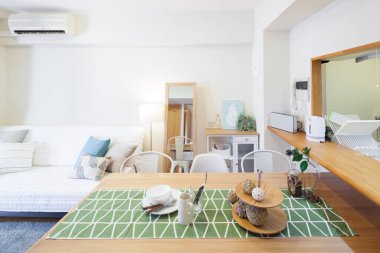 Koltuk ve masa gibi mobilyaları olan parlak bir oturma odası.