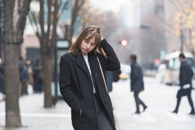 Kafkasyalı genç bir kadın endişeli ve endişeli bir ifadeyle dışarıda