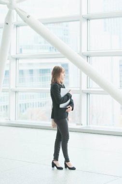 İş bölgesinde dizüstü bilgisayarı olan genç iş kadınının portresi.