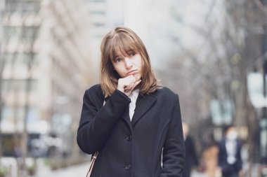 Kafkasyalı genç bir kadın endişeli ve endişeli bir ifadeyle dışarıda