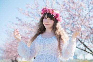 Genç beyaz kadın portresi, kiraz çiçekleri açmış.