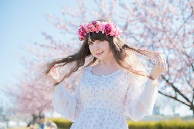 Genç beyaz kadın portresi, kiraz çiçekleri açmış.