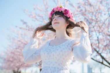 Genç beyaz kadın portresi, kiraz çiçekleri açmış.