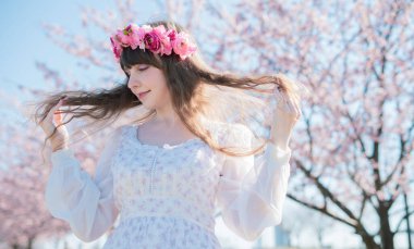 Genç beyaz kadın portresi, kiraz çiçekleri açmış.