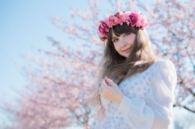 Genç beyaz kadın portresi, kiraz çiçekleri açmış.