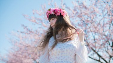 Genç beyaz kadın portresi, kiraz çiçekleri açmış.