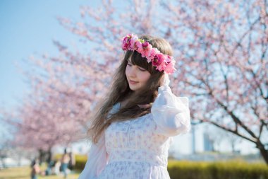 Genç beyaz kadın portresi, kiraz çiçekleri açmış.