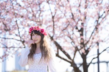 Genç beyaz kadın portresi, kiraz çiçekleri açmış.