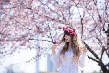 Genç beyaz kadın portresi, kiraz çiçekleri açmış.