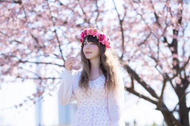 Genç beyaz kadın portresi, kiraz çiçekleri açmış.