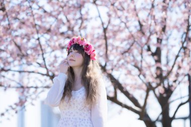 Genç beyaz kadın portresi, kiraz çiçekleri açmış.