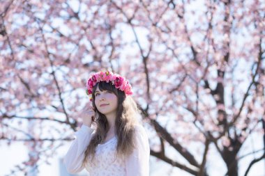 Genç beyaz kadın portresi, kiraz çiçekleri açmış.