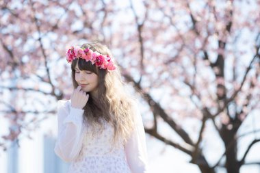 Genç beyaz kadın portresi, kiraz çiçekleri açmış.