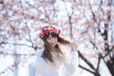 Genç beyaz kadın portresi, kiraz çiçekleri açmış.