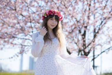 Genç beyaz kadın portresi, kiraz çiçekleri açmış.