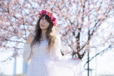 Genç beyaz kadın portresi, kiraz çiçekleri açmış.