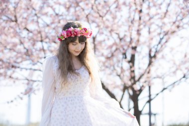 Genç beyaz kadın portresi, kiraz çiçekleri açmış.