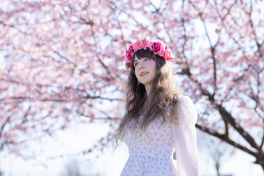 Genç beyaz kadın portresi, kiraz çiçekleri açmış.