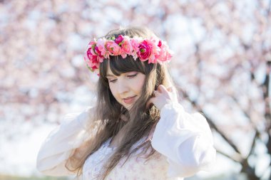 Genç beyaz kadın portresi, kiraz çiçekleri açmış.