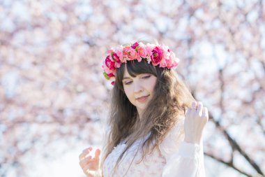 Genç beyaz kadın portresi, kiraz çiçekleri açmış.