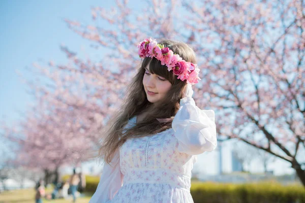 Genç beyaz kadın portresi, kiraz çiçekleri açmış.