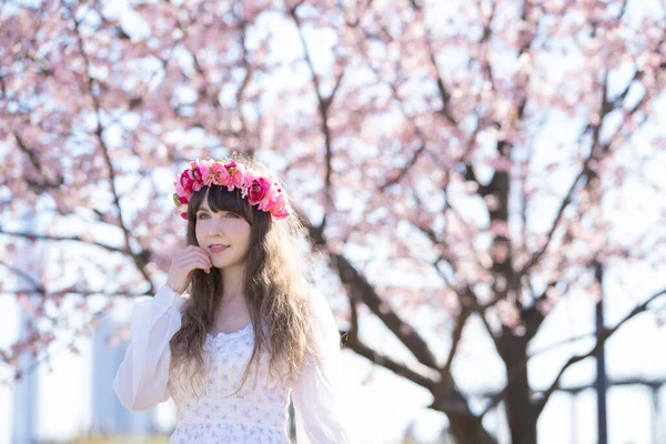 Genç beyaz kadın portresi, kiraz çiçekleri açmış.