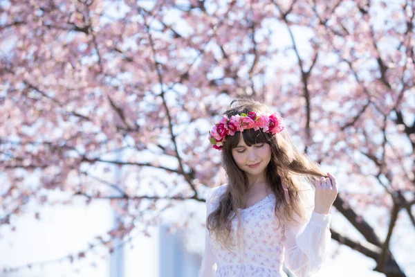 Genç beyaz kadın portresi, kiraz çiçekleri açmış.