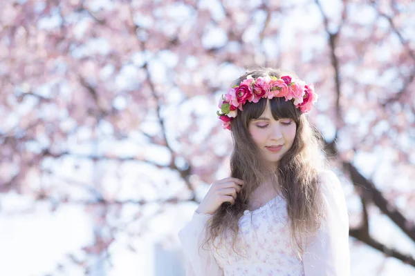 Genç beyaz kadın portresi, kiraz çiçekleri açmış.