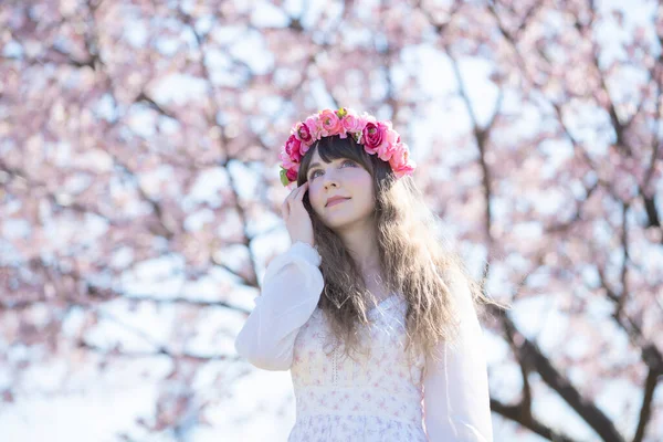 Genç beyaz kadın portresi, kiraz çiçekleri açmış.