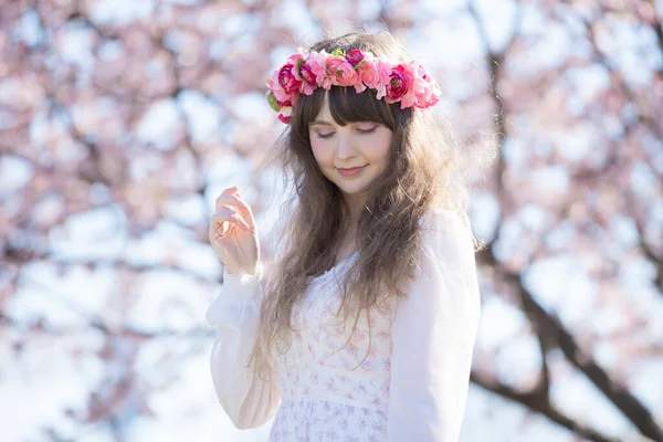 Genç beyaz kadın portresi, kiraz çiçekleri açmış.