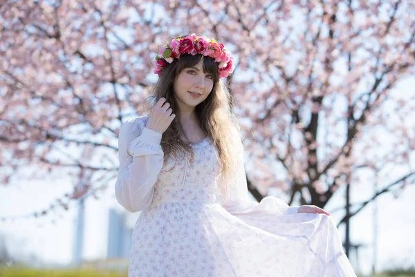 Genç beyaz kadın portresi, kiraz çiçekleri açmış.