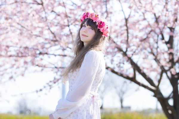 Genç beyaz kadın portresi, kiraz çiçekleri açmış.