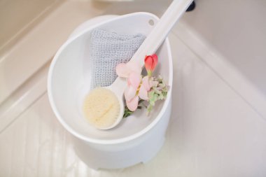 Dairedeki temiz bir banyoda vücut fırçası, sünger ve lavabo.