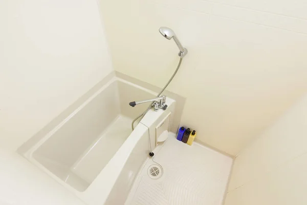 Wide angle photo of bright and cleanly cleaned bathroom with shower and bathtub